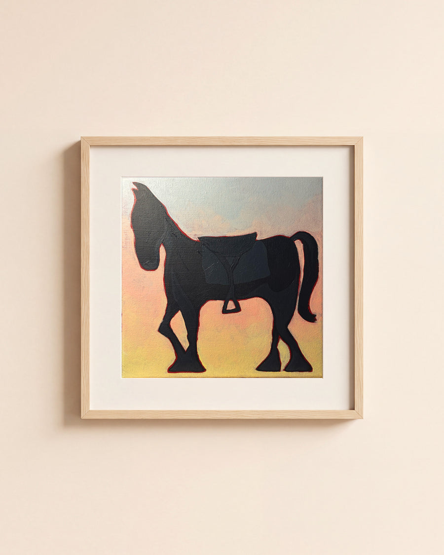 Black Horse giclée art print in a light oak frame with a white mat, hanging on a cream wall