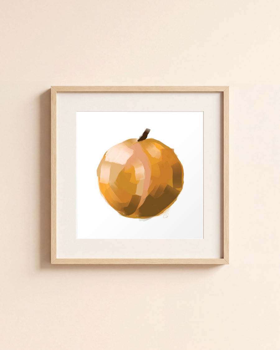 Orange giclée art print in a light oak frame with a white mat, hanging on a cream wall