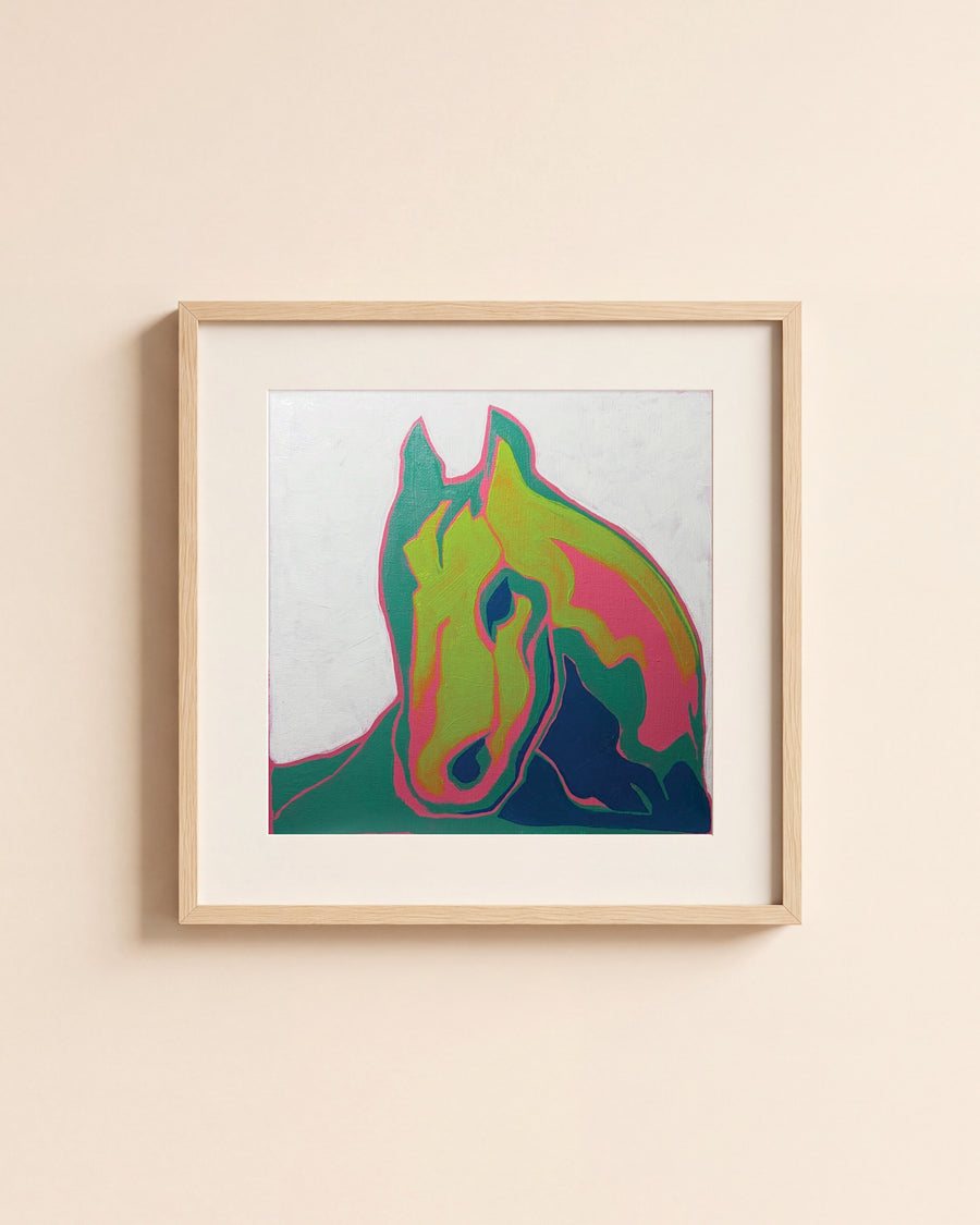 Pink & Green Horse giclée art print in a light oak frame with a white mat, hanging on a cream wall